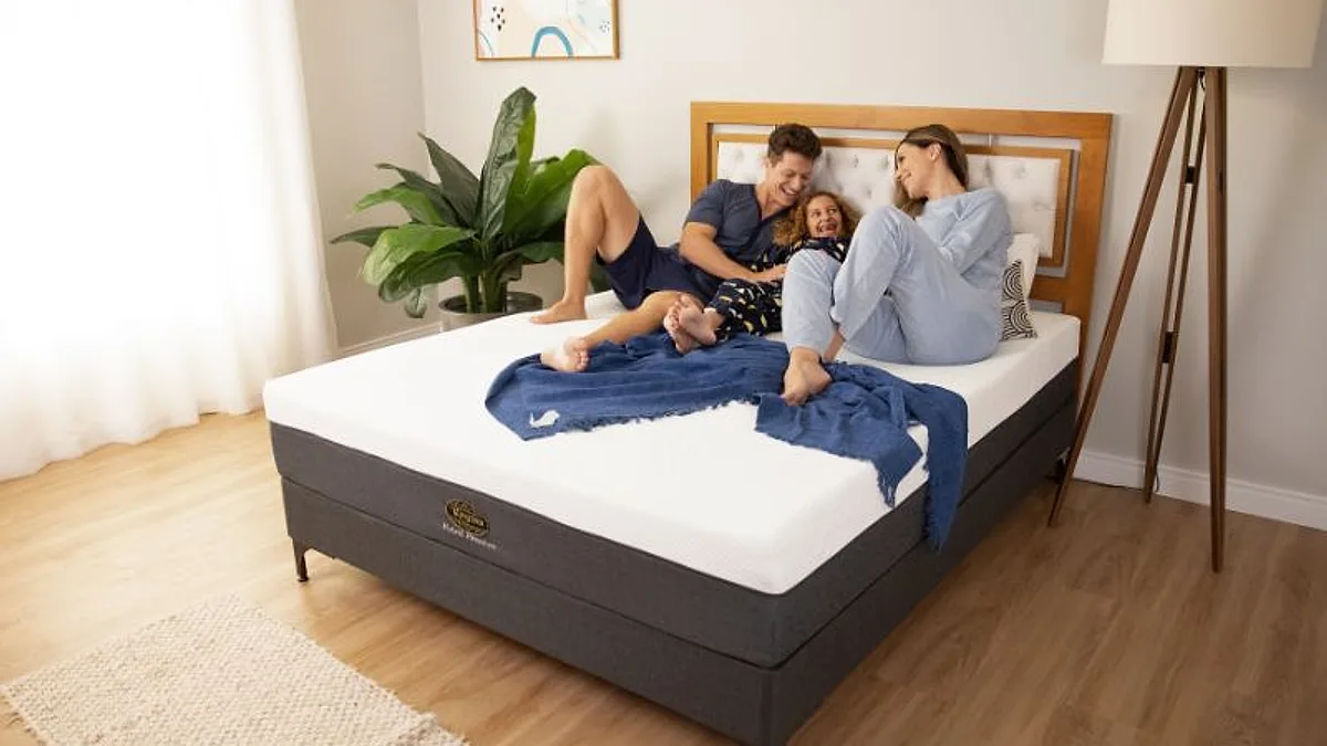 Família reunida sobre uma cama King Star em quarto claro