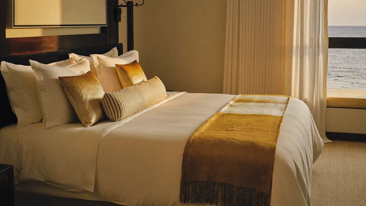 Cama king impecável com roupa de cama creme em quarto elegante